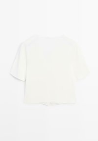 Chemisier court blanc à manches courtes avec un col rond et une petite fente subtile à l'ourlet arrière, présenté sur un fond blanc.