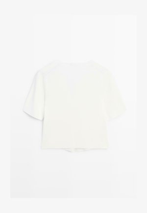 Camicia corta bianca a maniche corte con scollo rotondo e piccolo spacco nell'orlo posteriore, mostrata su sfondo bianco.