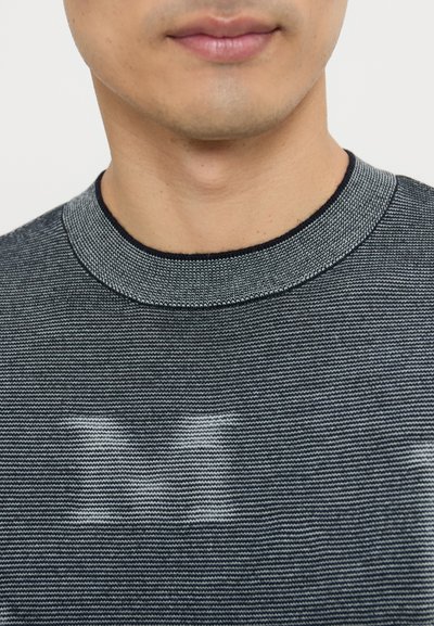 Maglione a girocollo nero e grigio con una trama a righe orizzontali sottili e un collo a coste, realizzato in un tessuto liscio e leggero.