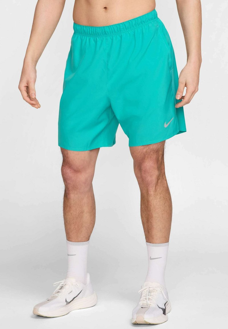 Calções atléticos turquesa com cintura elástica, apresentando bolsos laterais e um pequeno logotipo refletor da Nike na perna esquerda.