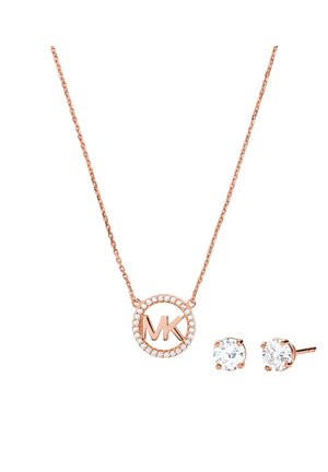 Una collana in oro rosa con un pendente circolare decorato con le iniziali "MK" circondate da cristalli scintillanti, abbinata a orecchini a perno coordinati.