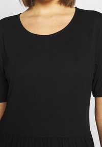 Schwarzes Kurzarmkleid mit einem runden Ausschnitt, das eine glatte Textur und einen ausgestellten Rock hat, aus leichtem Stoff gefertigt.