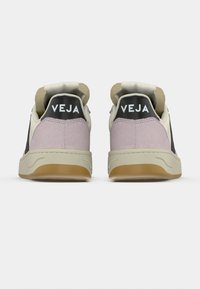 Αθλητικά παπούτσια με ροζ σουέντ επάνω μέρος, μαύρες λεπτομέρειες και μπεζ ελαστική σόλα. Στο πίσω μέρος εμφανίζεται η επωνυμία VEJA σε μαύρο πάνελ. Ορατή μαλακή επένδυση.