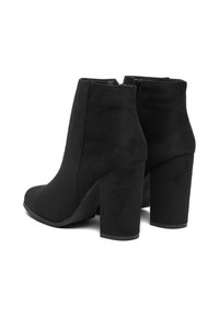 Stivali neri in suede fino alla caviglia con una finitura testurizzata, caratterizzati da una punta tondeggiante e un tacco spesso, con una chiusura a zip liscia sul retro.