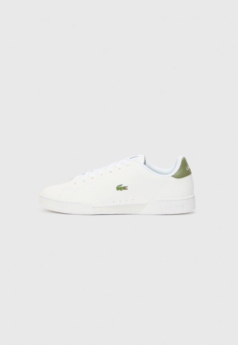 Hvite joggesko med en glatt tekstur, med en grønn detalj på hælen og en liten brodert krokodillelogo på siden.