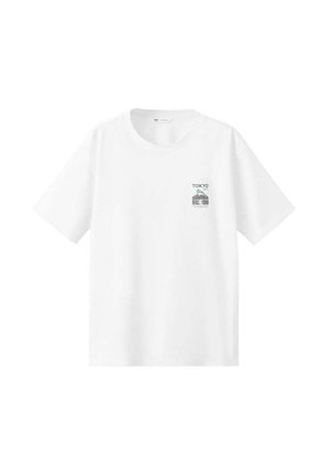 T-shirt blanc à manches courtes avec un petit motif sur la poitrine représentant le Mont Fuji, un palmier et le mot « TOKYO » au-dessus de l’image.