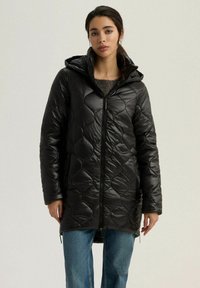 Czarna pikowana kurtka puchowa z kapturem, z zapięciem na zamek i bocznymi kieszeniami. Miękka, błyszcząca tekstura i długość do kolan.