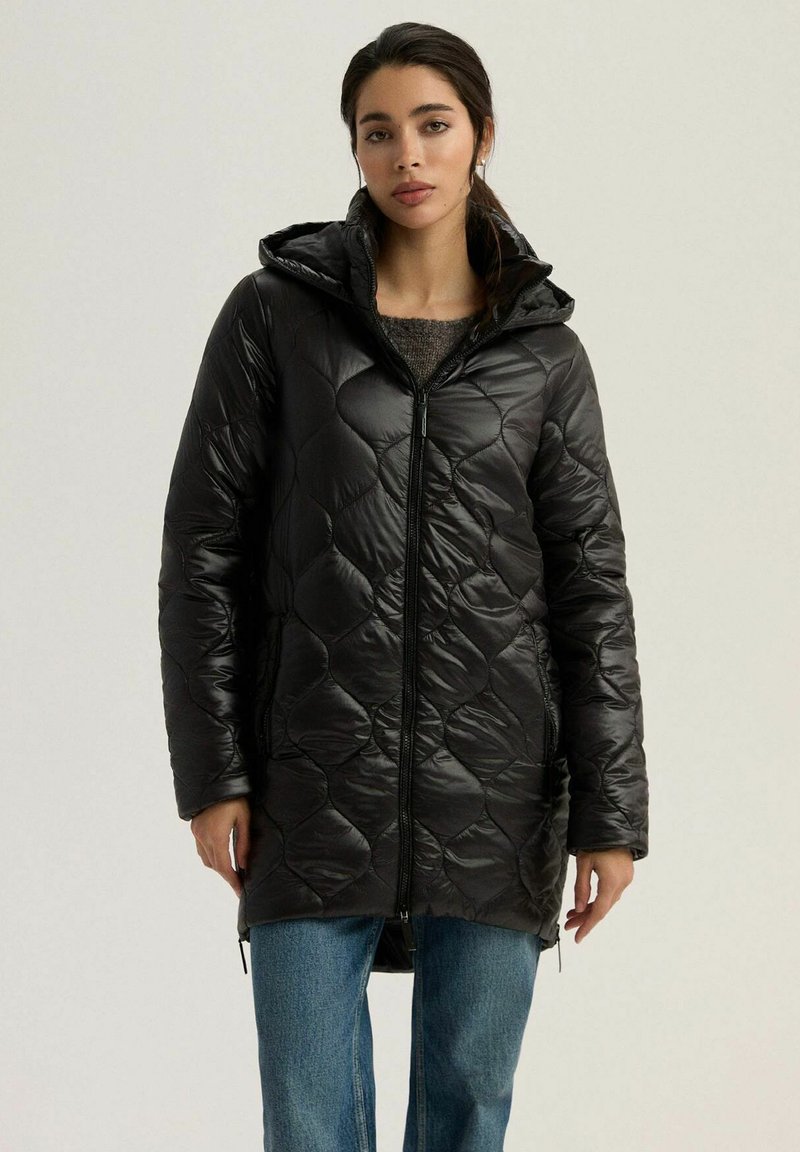 Czarna pikowana kurtka puchowa z kapturem, z zapięciem na zamek i bocznymi kieszeniami. Miękka, błyszcząca tekstura i długość do kolan.