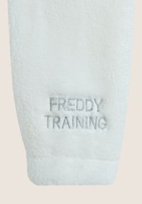 Pantaloni da tuta in pile bianco con la scritta "FREDDY TRAINING" ricamata in filo argentato. Tessuto morbido con un design a gamba leggermente affusolata.