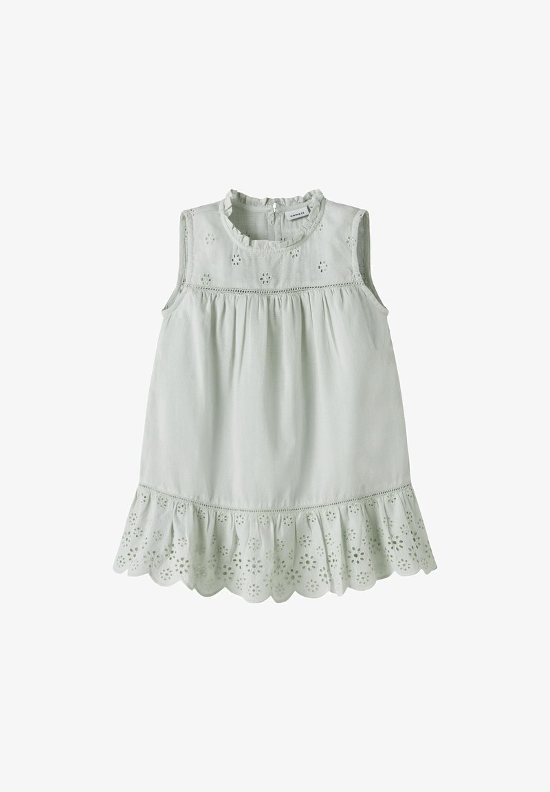 Robe blanche sans manches pour tout-petit avec broderie florale ajourée, col à volants et ourlet festonné.
