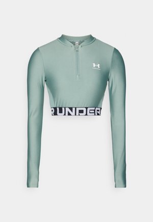 Miętowa, skrócona bluzka z długim rękawem z pół zamkiem i czarnym elastycznym pasem z napisem "UNDER ARMOUR". Gładki, rozciągliwy materiał.