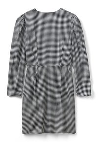 Abito in bianco e nero con motivo houndstooth, maniche lunghe, scollatura tonda e dettagli arricciati in vita. Tessuto morbido e testurizzato.