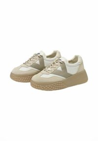 Sneaker beige con un mix di materiali lisci e testurizzati, una suola spessa con un motivo a pois e un design stratificato con accenti chiari.