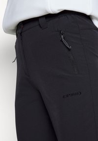 Czarne spodnie outdoorowe z miękkiej tkaniny, z kieszenią na zamek błyskawiczny i detalem z logo. Dopasowany krój oraz gładka faktura zapewniająca komfort.