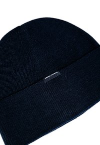 Cappello di lana a coste di un blu navy scuro con risvolto e piccolo etichetta nera con la scritta "Armani Exchange" in bianco.