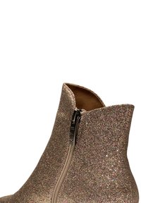 Botín brillante en beige con cierre metálico. Cuenta con una superficie texturizada y brillante, y un diseño elegante y moderno.