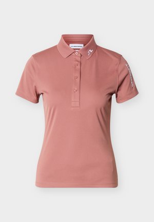 Short-sleeve dusty pink polo shirt with collar, four buttons, and white J.Lindeberg logo on collar and right sleeve.