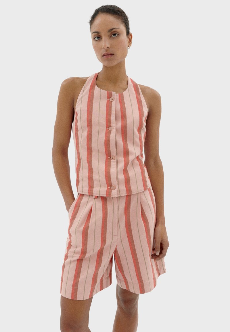 Roze gestreepte twee-delige outfit met een mouwloos topje met knopen en bijpassende shorts, beide gemaakt van geweven stof.