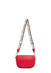 Punainen nahkainen olkalaukku kaarevalla muotoilulla, jossa on logo ja kangashihna, jossa on mustavalkoinen "Pepe Jeans" -teksti.