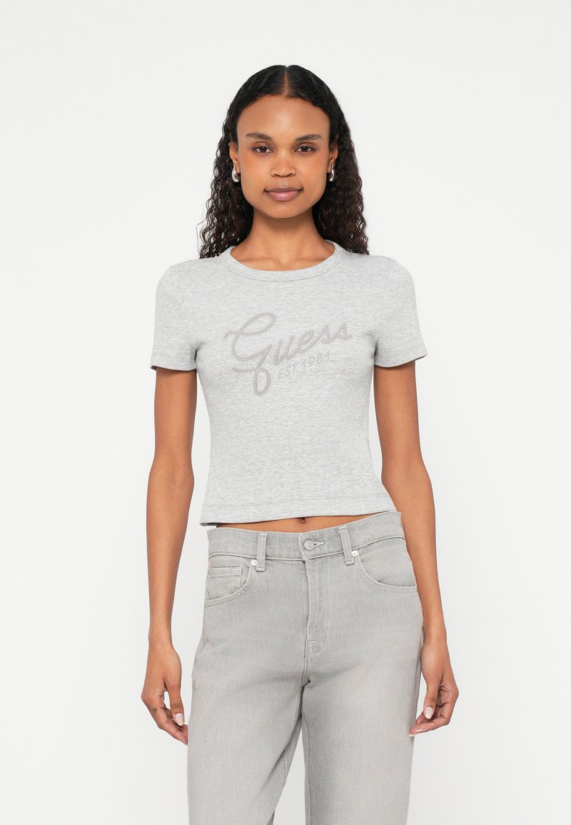 Gray cropped t-shirt with short sleeves, featuring a rhinestone logo design "Guess EST. 1984" across the chest. Soft cotton material.