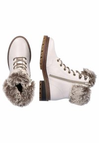 Des bottines en cuir blanc avec un trim en fausse fourrure, une semelle en caoutchouc marron, un bout rond et des œillets en métal avec des lacets tressés. Fermeture éclair sur le côté visible.