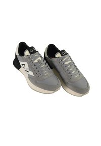 Scarpe sportive grigie realizzate in tessuto e suede, con accenti bianchi e neri, chiusura con lacci e una suola testurizzata.