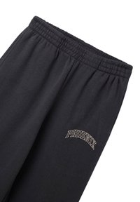 Czarne dresy z elastycznym pasem i wyszywanym logo "PHOENIX" w kolorze beżowym. Miękka tkanina i luźny krój, bez dodatkowych wzorów.