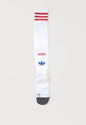 Biała sportowa skarpeta z czerwonymi paskami u góry, czerwonym napisem "MUFC", niebieskim logo Adidas i szarą częścią palcową.