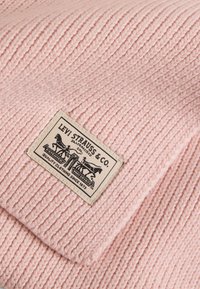 Pink knitted beanie featuring ribbed texture and a sewn tan label with the Levi Strauss & Co. logo and text.