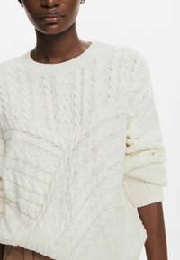 Maglione spesso bianco a maglia grossa con scollo rotondo, motivi testurizzati e polsini a coste, caratterizzato da una vestibilità rilassata e un look a strati.