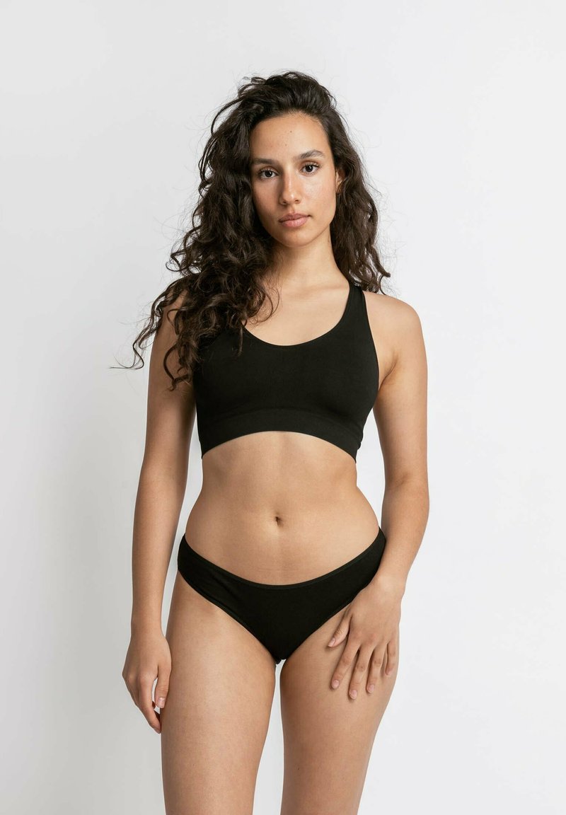 Zwarte cropped tanktop met brede banden en bijpassende low-rise onderbroek; beide gemaakt van een gladde, rekbare stof.
