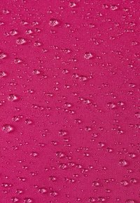 Wodoodporny różowy materiał o teksturowanej powierzchni, z małymi kroplami wody równomiernie rozproszonymi po powierzchni.