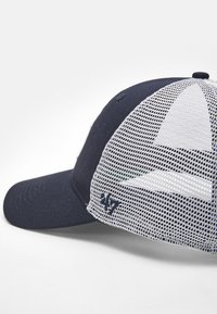 Gorra de béisbol azul marino con parte trasera de malla, visera curva, detalle de logotipo bordado y correa ajustable. Tela texturizada y diseño estructurado.