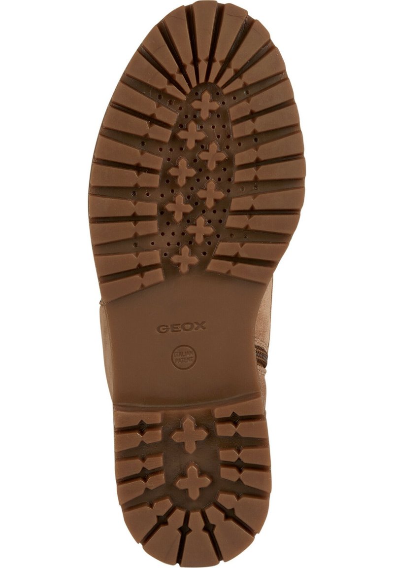 Zool van een bruine laars met diepe noppen, kruisvormige patronen, merknaam "GEOX" en kleine perforaties voor ademend vermogen.