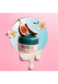 Maschera per capelli Coco & Eve in un contenitore rosa con un coperchio turchese; presenta cocco, fico e fiori bianchi su uno sfondo rosa.