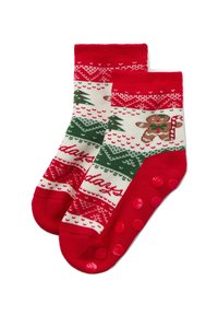 Red and cream holiday-themed socks with green trees and a gingerbread man pattern, textured bottom with pink grip dots, ribbed cuff.