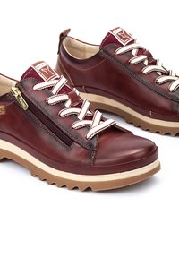 Scarpe in pelle marrone con lacci crema e dettaglio con zip. Punta rotonda, suole testurizzate e accenti bordeaux in contrasto sul colletto.
