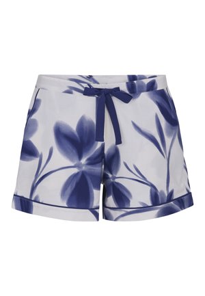 Białe szorty z dużymi niebieskimi kwiatowymi wzorami, granatową sznurówką z kokardą w pasie oraz podwiniętymi nogawkami.