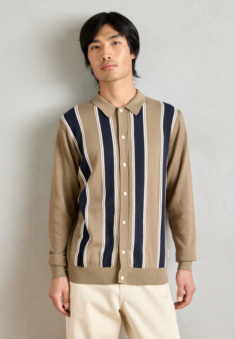 Beige och marinblå randig kofta med krage, knappstängning, ribbade ärmslut och nederkant; mjuk textur och avslappnad passform.