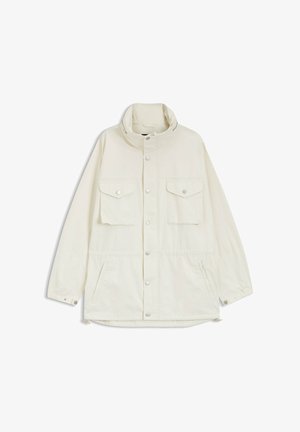 Veste longue à manches longues de couleur blanc cassé avec col montant, boutons-pression à l'avant, deux poches poitrine à rabat, deux poches latérales, poignets élastiques avec fermetures à bouton-pression.