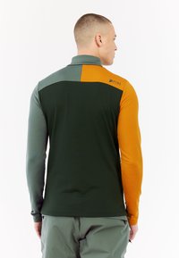 Langarm T-Shirt met een kleurblokontwerp in groen, grijs en oranje. Soepele textuur met hoge kraag en logo-detail op de schouder.