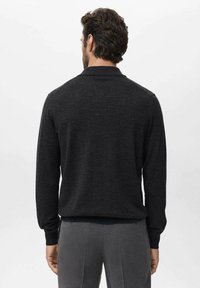 Dark gray long-sleeve polo shirt with a subtle texture, featuring a collar and cuffed sleeves, designed for a fitted appearance.