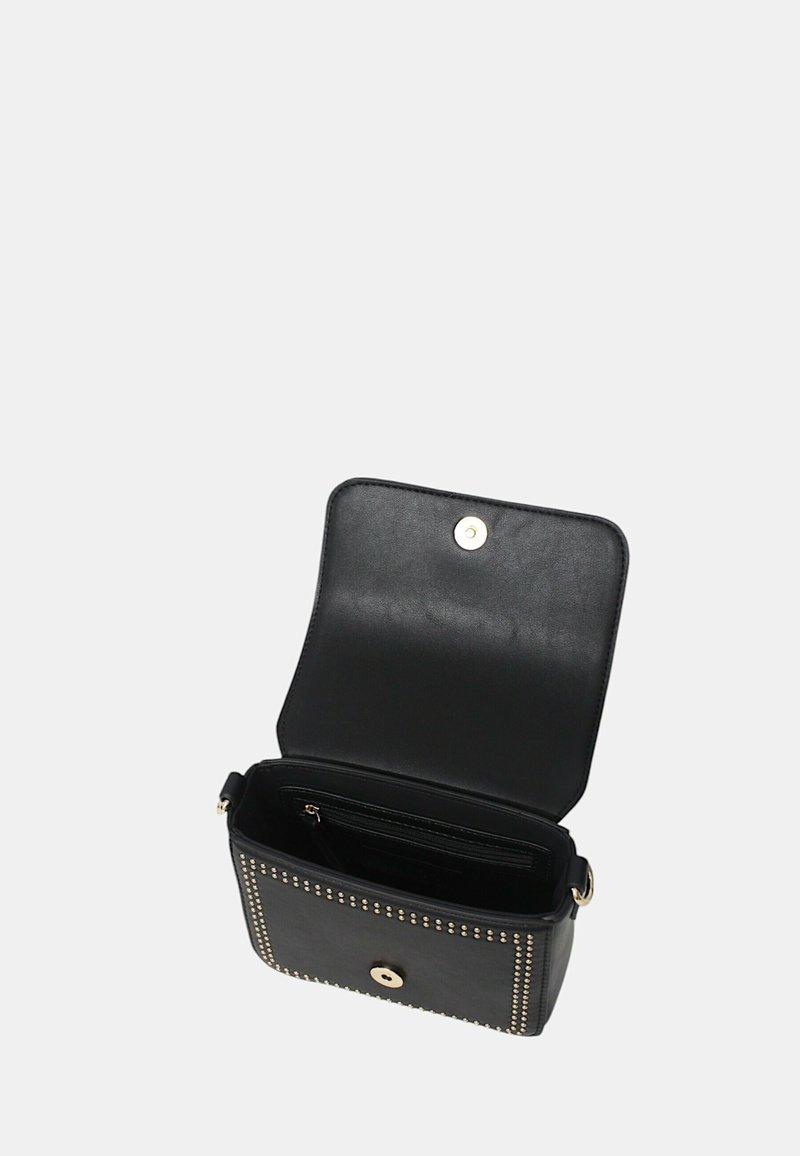 Bolso cruzado de cuero negro con detalles de tachuelas doradas, tapa abierta que revela un bolsillo interior con cremallera y cierre magnético sobre fondo liso.