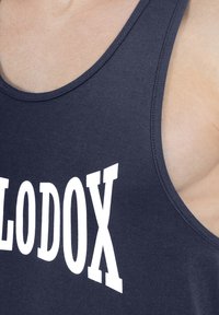 Granatowy tank top wykonany z bawełny, z dużym białym napisem "LODODX" na piersi, okrągłym dekoltem i bez rękawów.