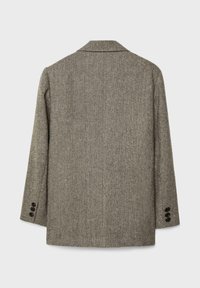 Marynarka w jodełkę w szarym kolorze z wełny, z kołnierzem, pojedynczym rozcięciem i trzema czarnymi guzikami przy każdym mankiecie. Minimalistyczny design, bez kieszeni.
