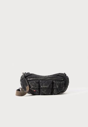 Black fabric bag with multiple pockets, textured surface, curved shape, and a detachable strap. Zipper closures and contrasting strap color.