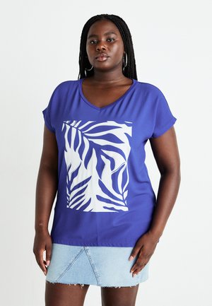 Blue short-sleeve V-neck shirt with a white zebra stripe graphic. Model paired it with a light denim skirt showcasing frayed edges.