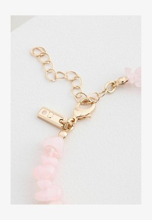 Kuldtooni klamber, millel on tekstuuriga homaariklamber, kinnitatud ebaühtlaste roosade vääriskivide helmed, millel on poleeritud viimistlus.