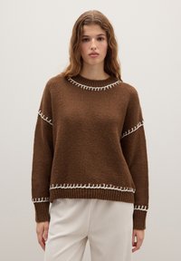 Brauner gestrickter Pullover mit weißen Nähten um den Halsausschnitt und den Saum. Verfügt über einen lässigen Schnitt und einen strukturierten Stoff.