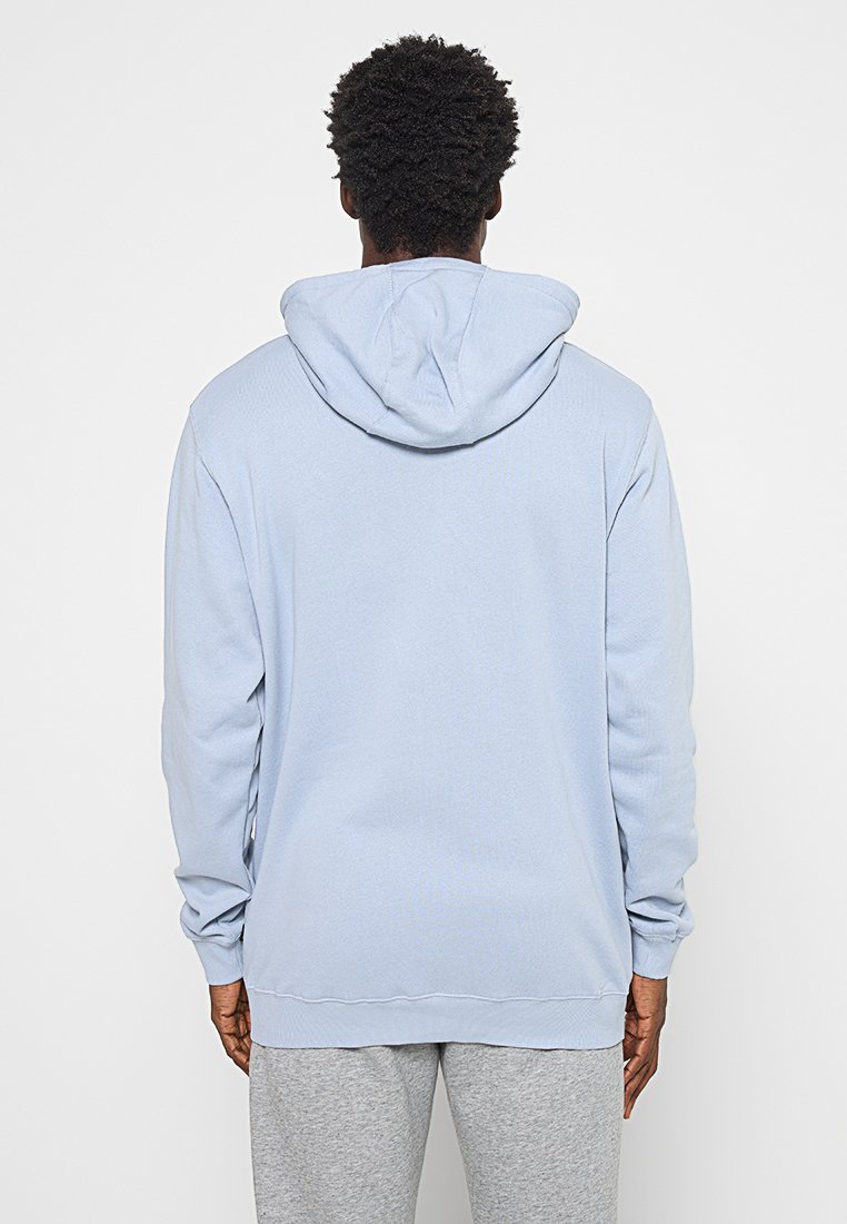 Hellblaues Hoodie aus weichem Stoff, mit Kapuze und Kordelzug, langen Ärmeln sowie gerippten Bündchen und Saum. Glatte Textur, lockere Passform.